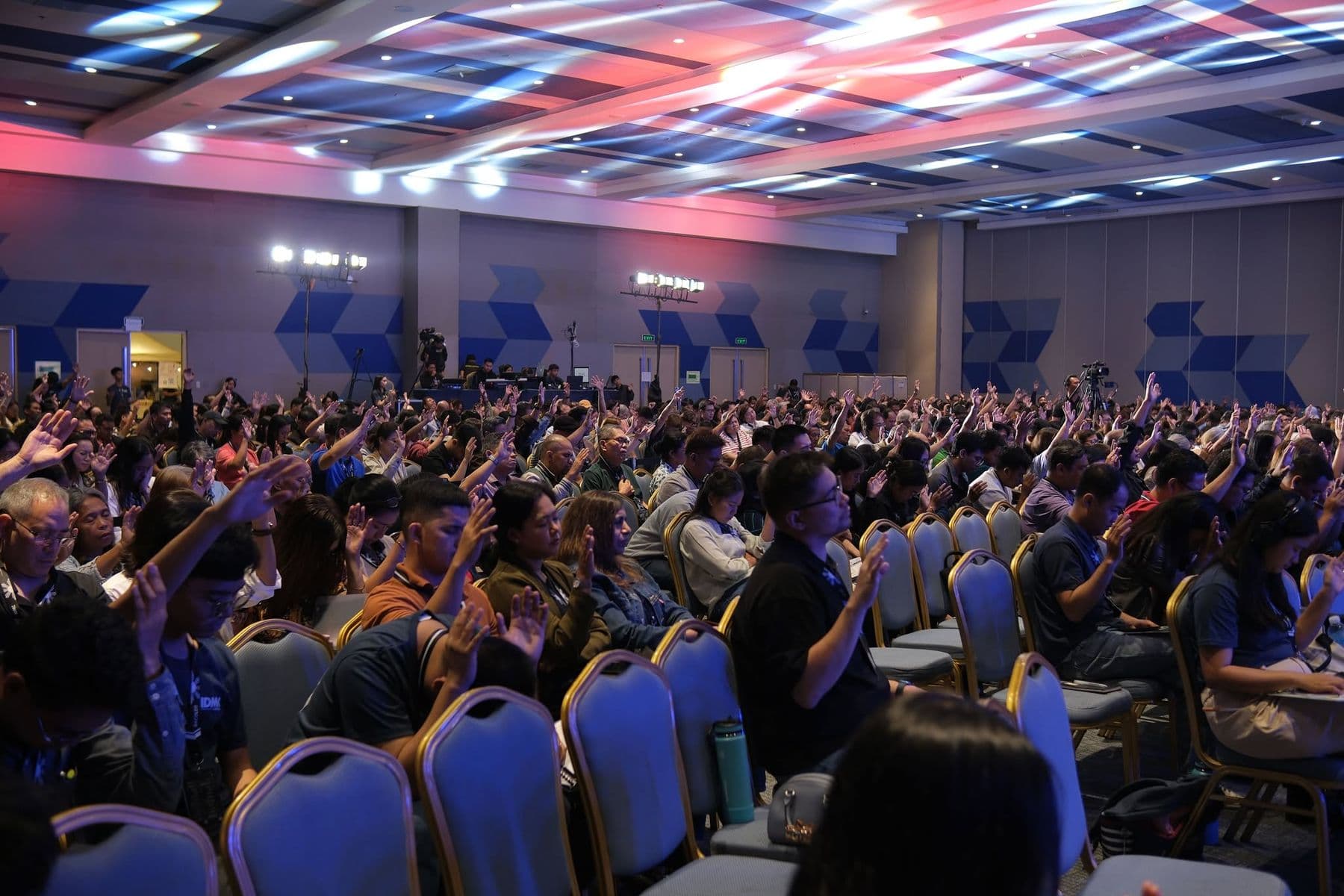 Delegates across the hall responding with raised hands
