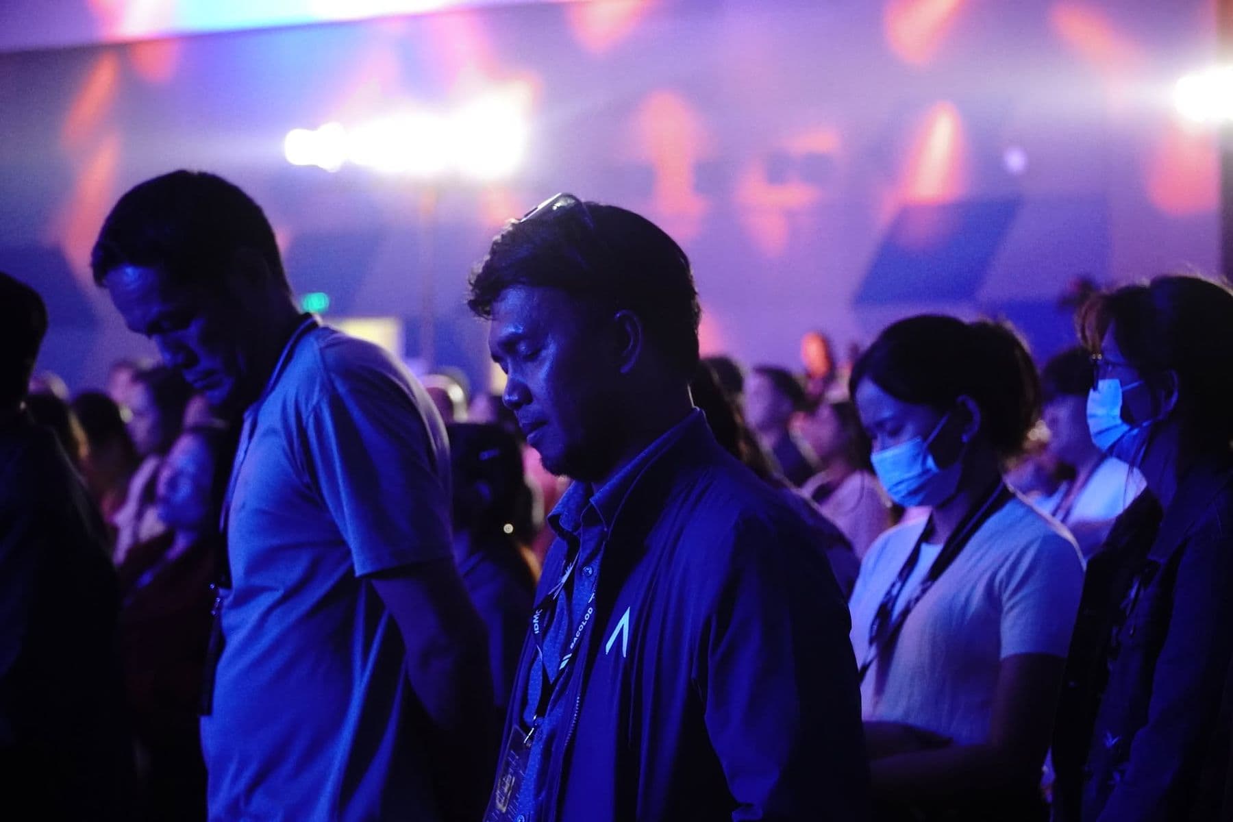 Delegates with heads bowed during a time of response