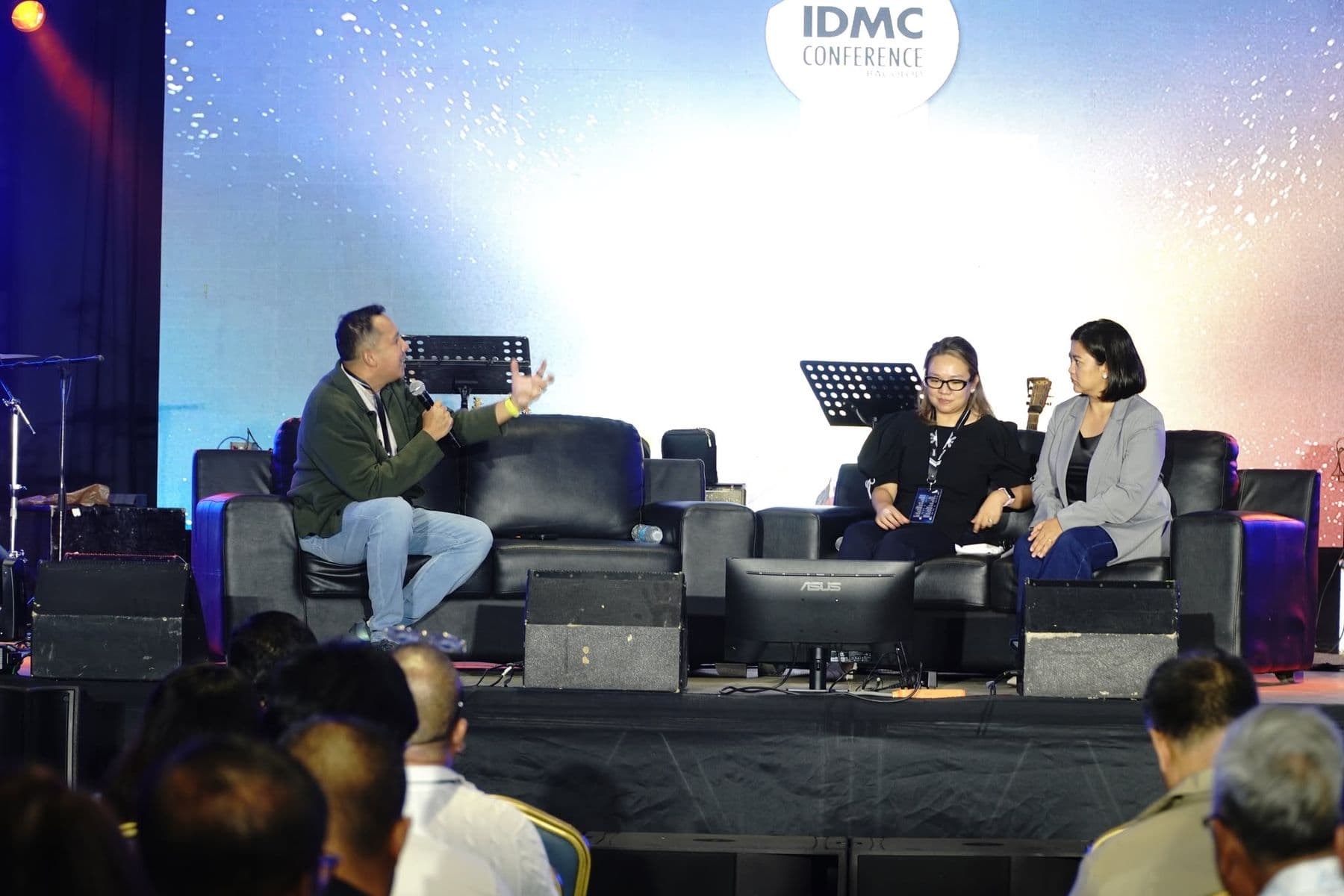 Three people seated on stage in a panel conversation