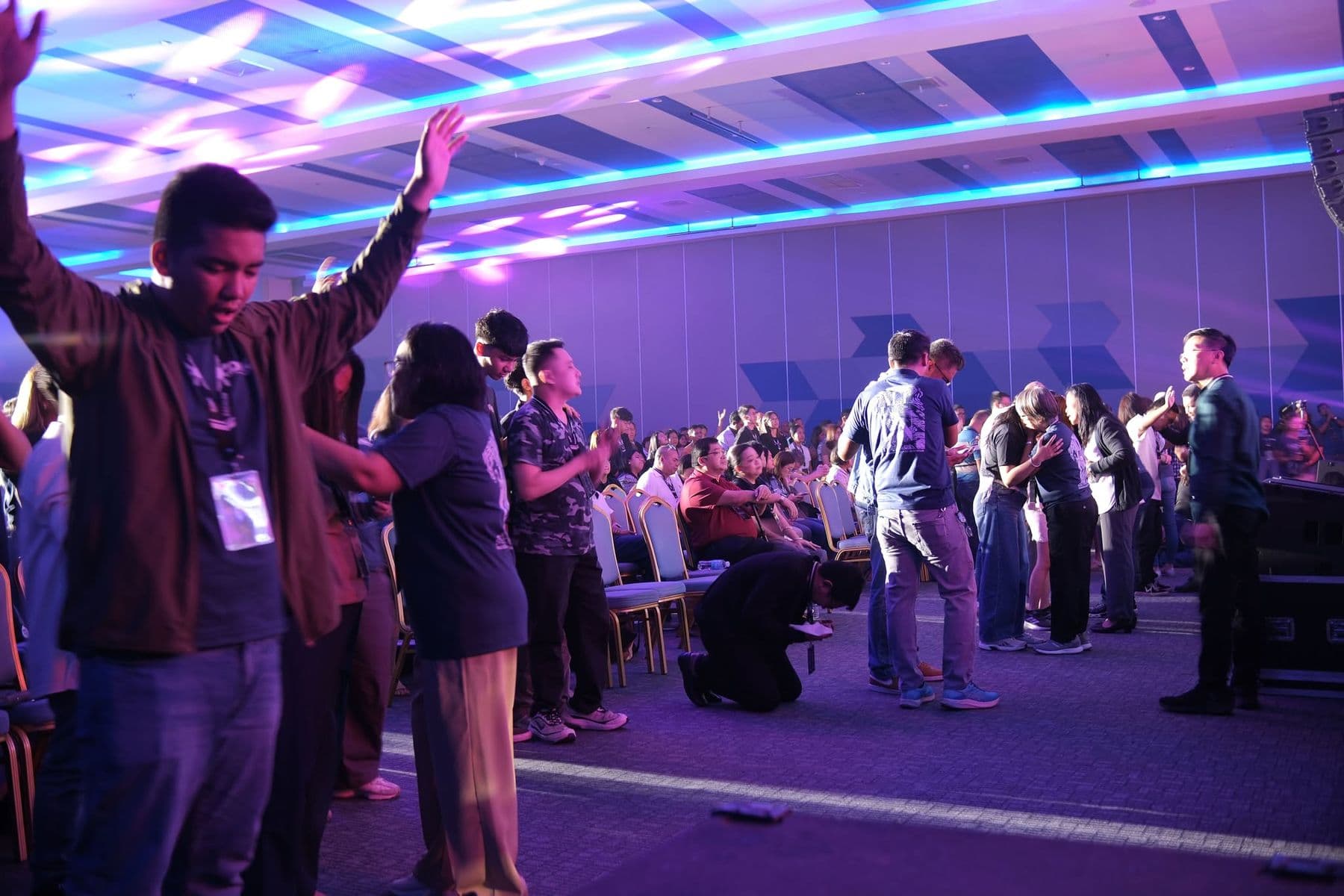 Delegates praying together at the front of the hall