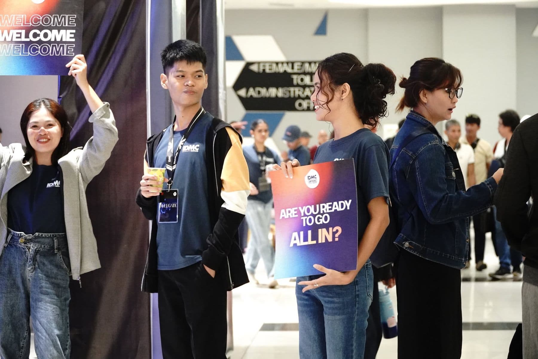 Volunteers at the entrance holding a sign that reads Are you ready to go all in?
