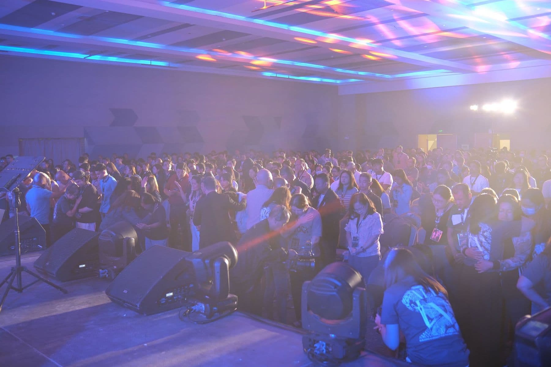 Stage haze and light over a hall full of worshippers